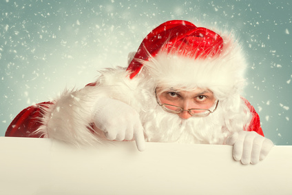 Santa Claus in a snow pointing to white blank banner
